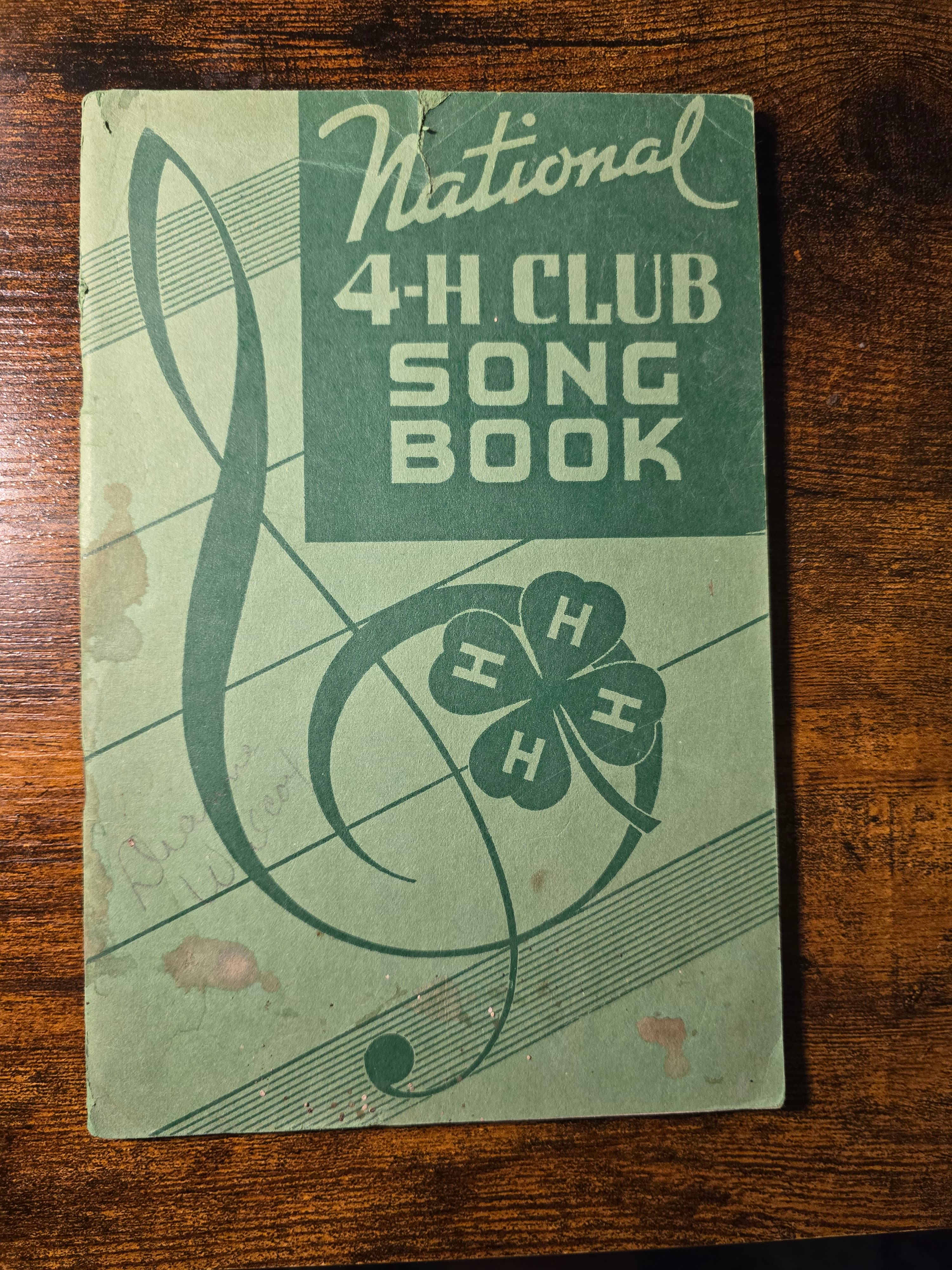 Vintage green National 4-H Club Song Book cover with musical staff and four-leaf clover