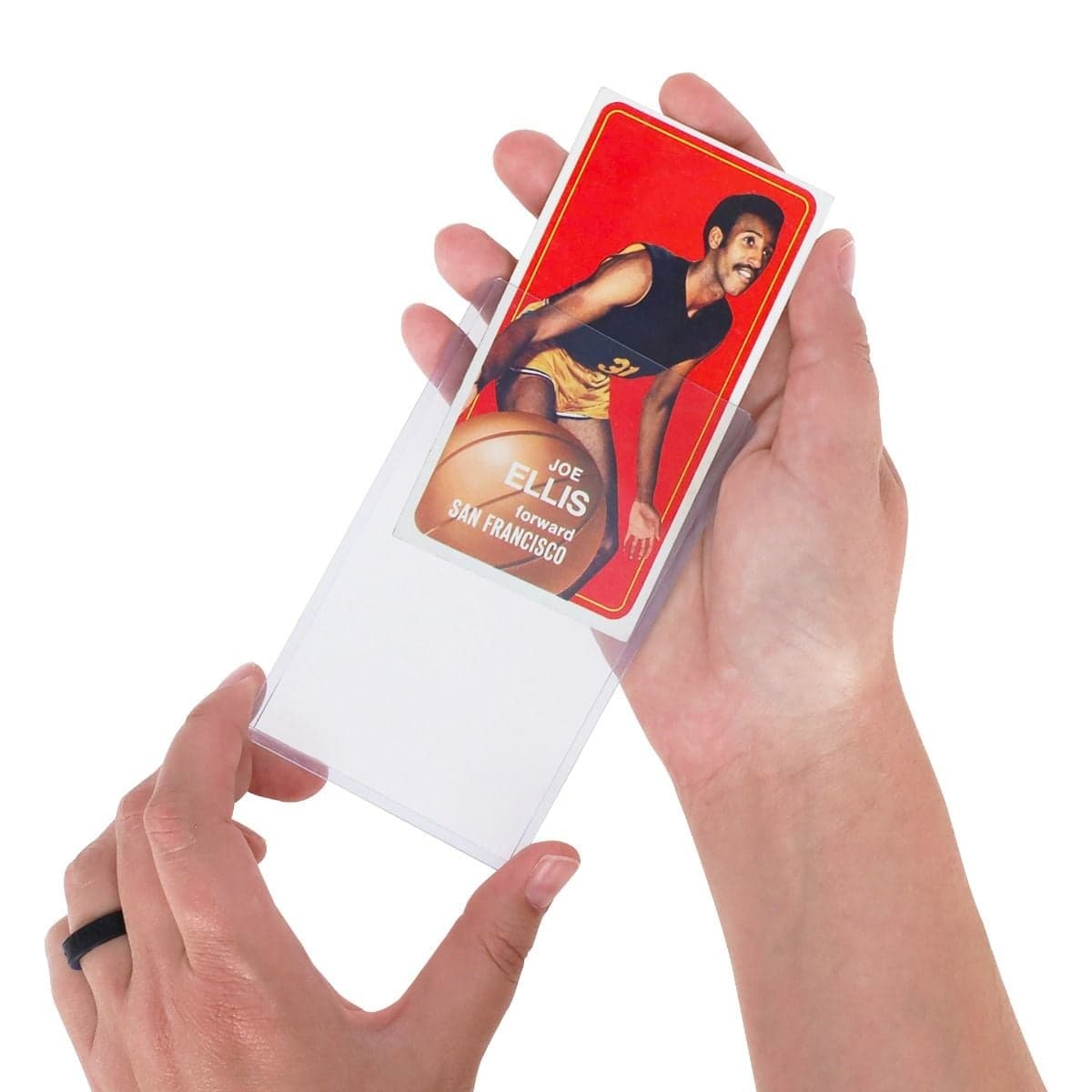 Hands inserting a tall basketball trading card into a clear BCW 3" x 5" tall topload card holder for protective storage and display.