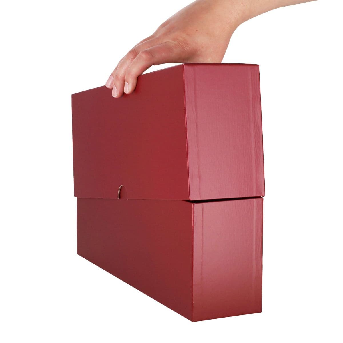 Alt text: BCW Slotted Graded Card Storage Box shown closed with a hand lifting it from the top, demonstrating its durable burgundy cardstock construction and secure lid for safely transporting up to 26 graded trading card slabs.