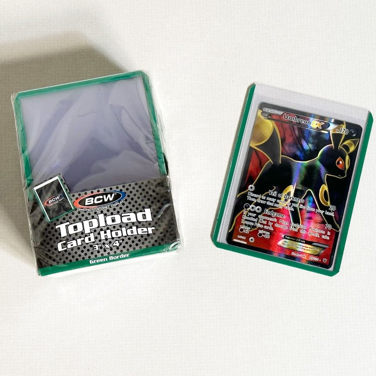 Pack of BCW Topload Card Holders 3x4 with green border. Group picture with Pokemon card in holder
