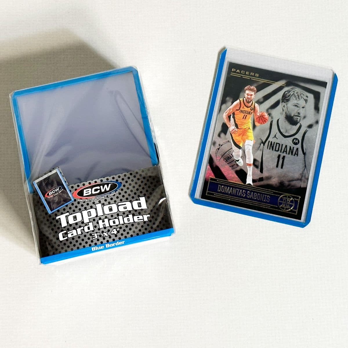 Pack of BCW Topload Card Holders 3x4 with blue border. Group picture with basketball card in holder