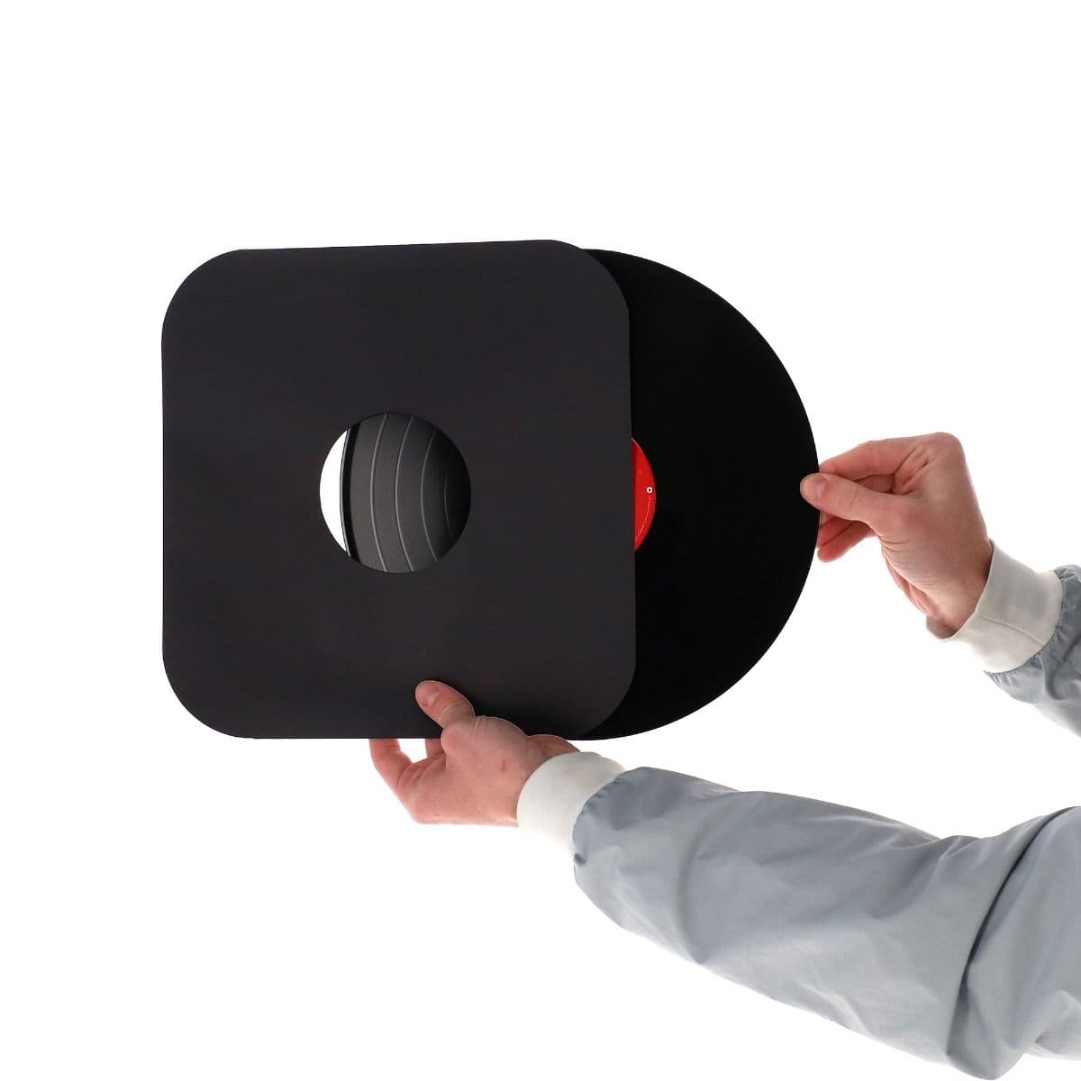 BCW 12 Inch Record Paper Inner Sleeves - Round Corners - With Hole - Black, hand holding and inserting a record into the record inner sleeve