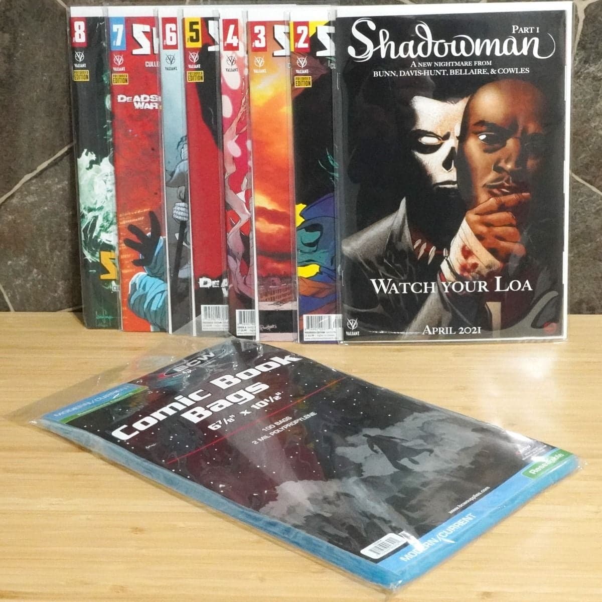BCW Resealable Comic Book Bags. Current, Modern. 100 bags next to a display of comics in bags