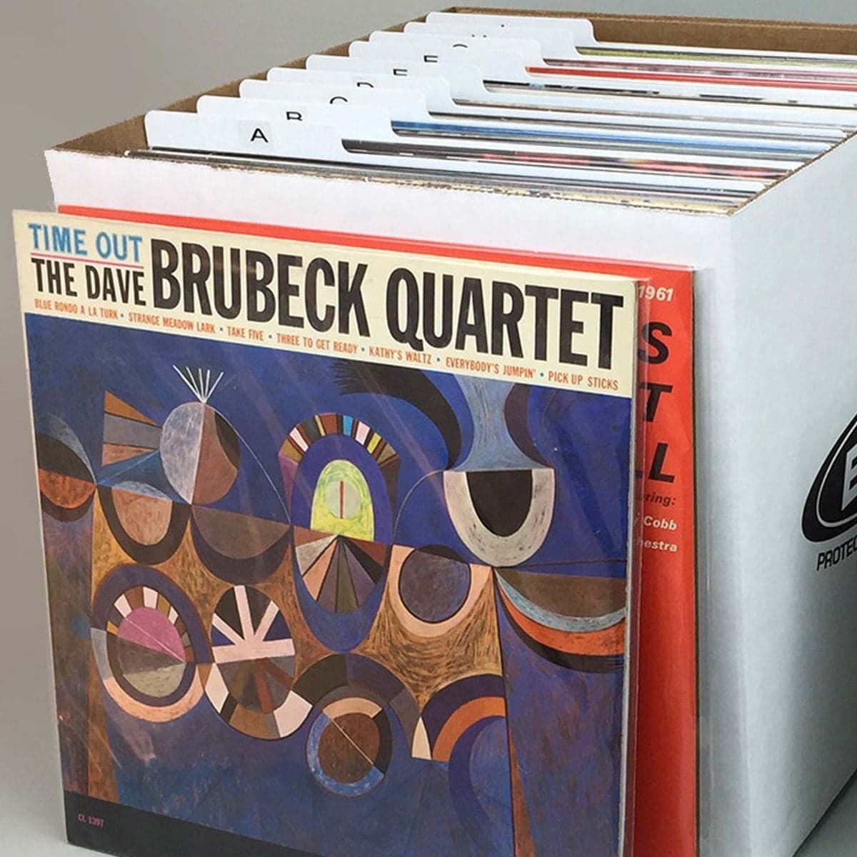 Records in front of 33RPM record box with dividers inside