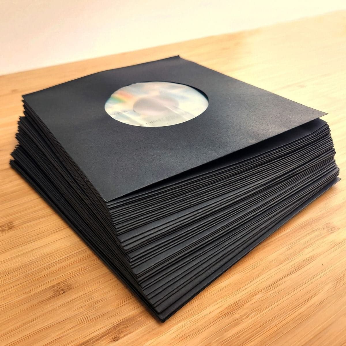 Angled image of a stack of BCW 7 Inch Record Paper Inner Sleeves - Polylined - With Hole - Black
