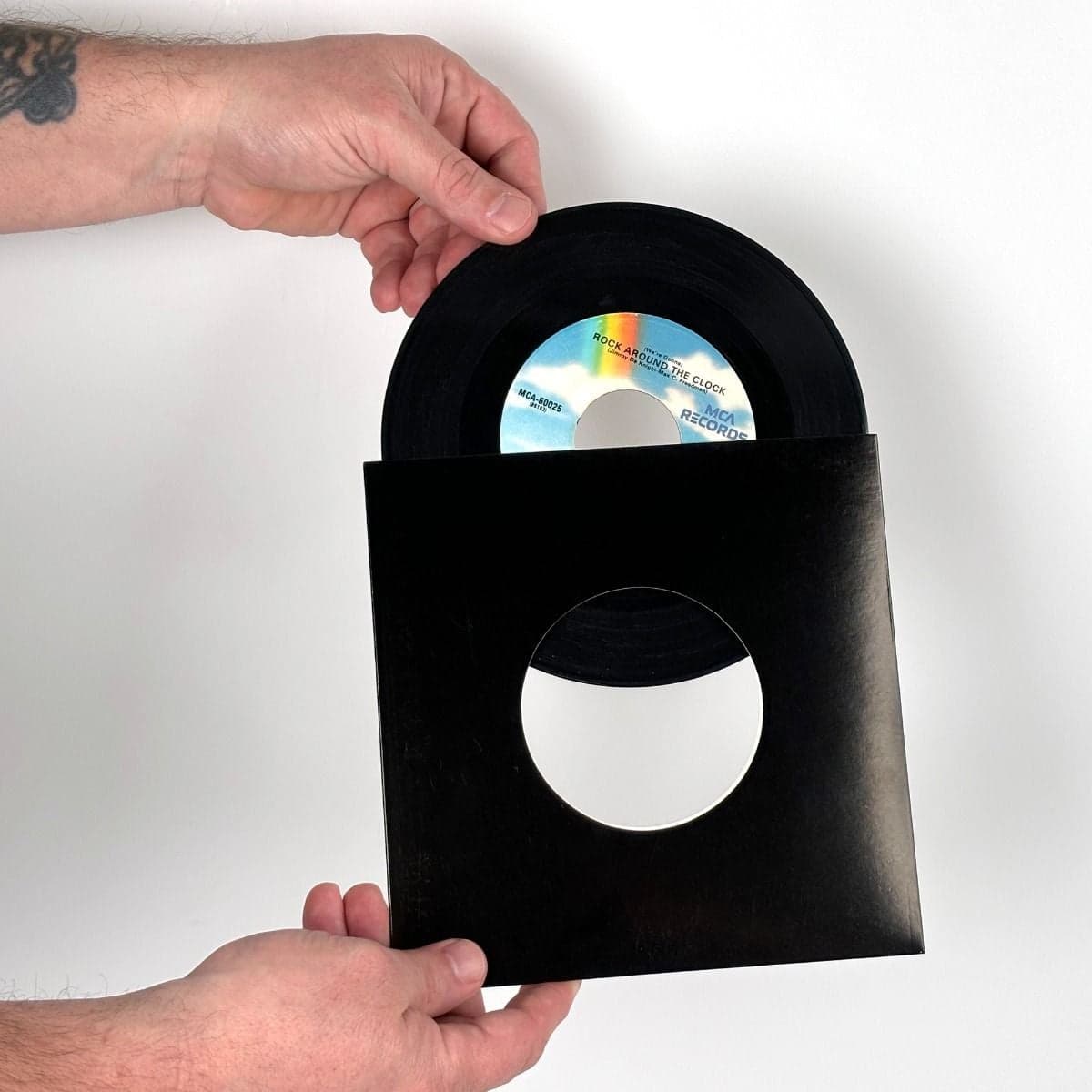 7 Inch Record Paper Jacket - With Hole - Black hand inserting record into jacket
