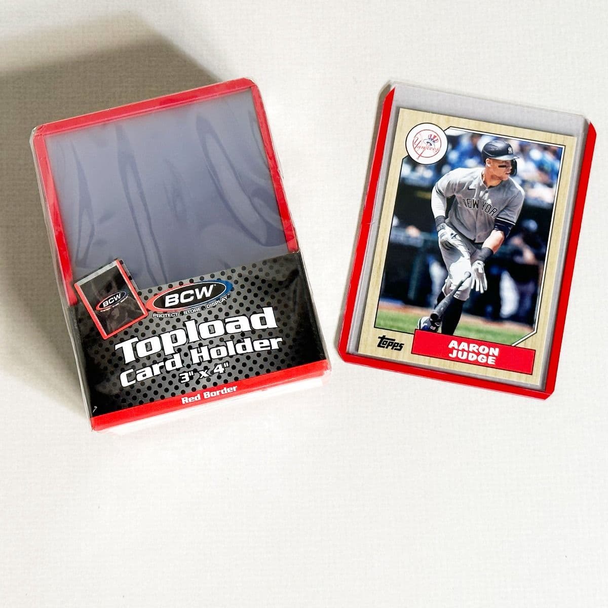 Pack of BCW Topload Card Holders 3x4 with red border. Group picture with baseball card in holder