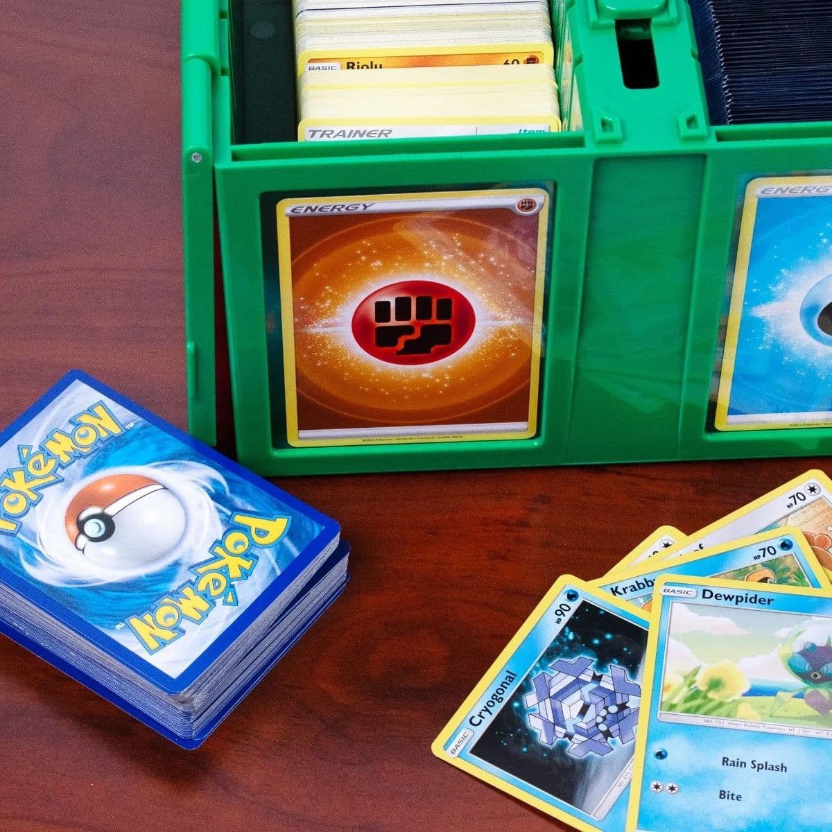 Collectible Card Bin - 1600 - Green pokemon cards open on table with stack and spread of pokemon cards
