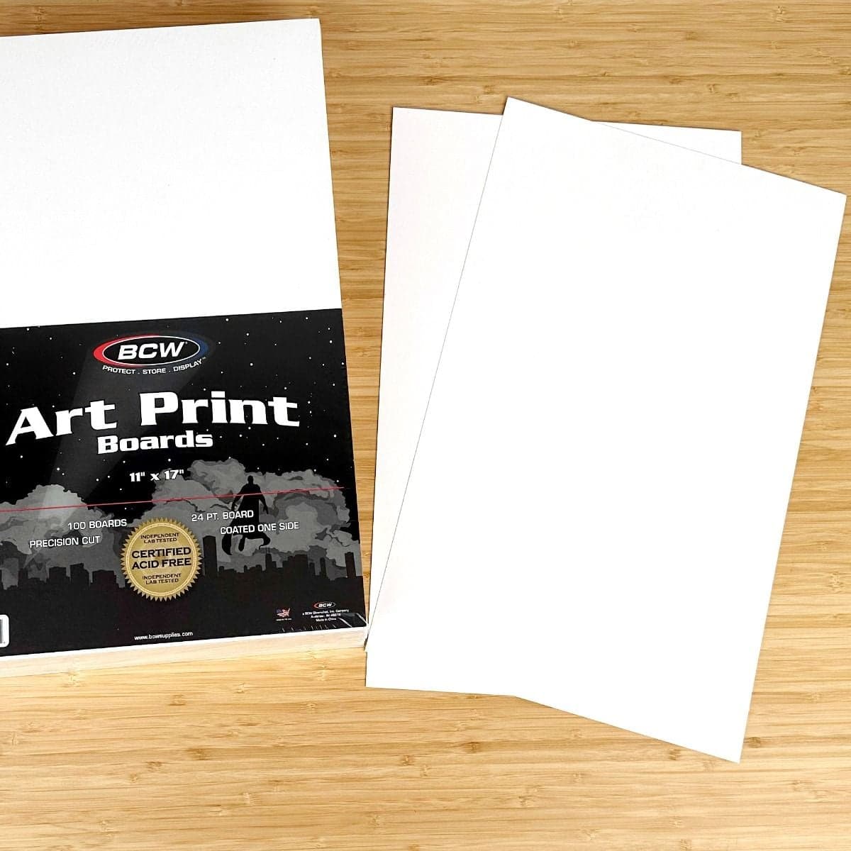 Package of BCW 11 inch by 17 inch Art Print Board with boards displayed next to packaging