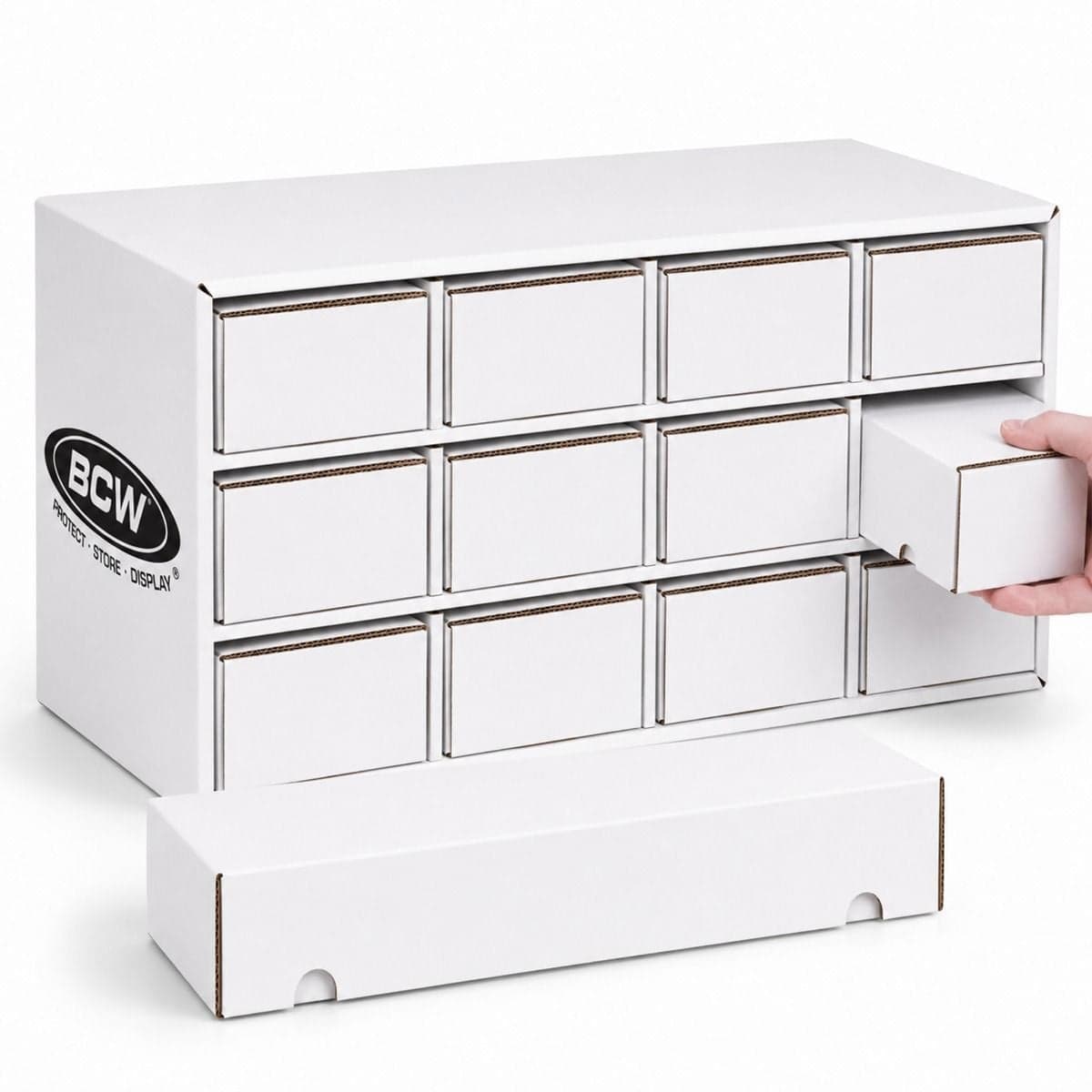 BCW Card House storage system with twelve white cardboard storage drawers arranged in three rows of four. One drawer is partially pulled out by a hand to demonstrate easy access, while another drawer is placed in front of the unit. The BCW logo is printed
