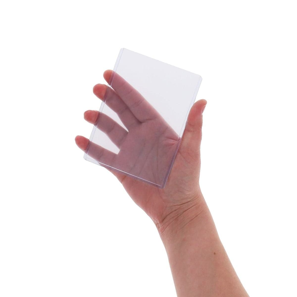Hand holding a clear BCW 3.5 x 5 rigid toploader to show the compact size and transparent PVC construction for protecting photos and prints.