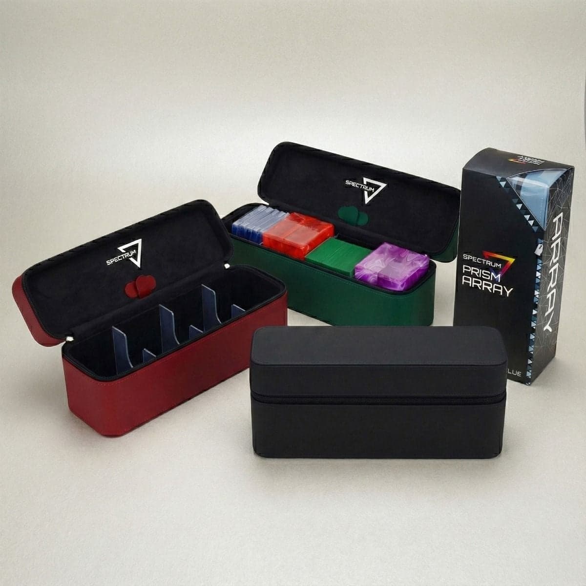 Black zippered trading card storage case in front, with additional cases in red (right), green (behind), and a blue version shown in retail packaging; one open case reveals interior dividers and colorful deck boxes neatly stored inside.