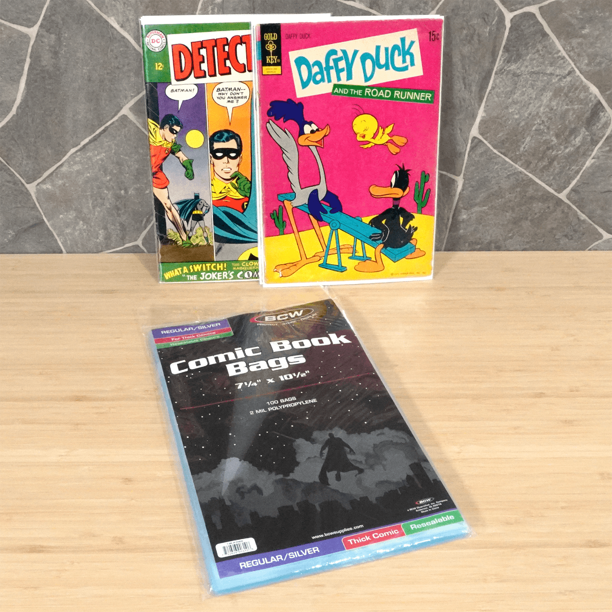 Package of BCW Resealable Silver Age Thick Comic Book Bags with Daffy Duck and Batman comic books bagged and boarded