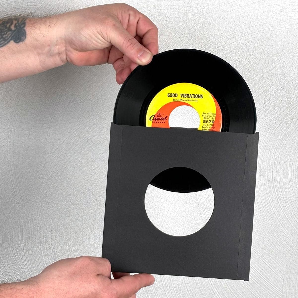 7 Inch Record Paper Inner Sleeves - Square Corners - With Hole - Black inserting record into sleeve