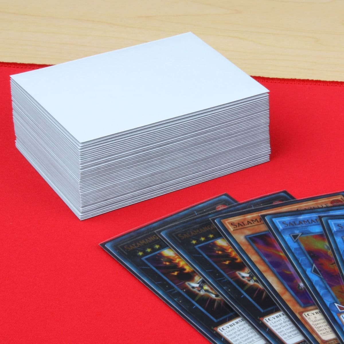 Five cards inside BCW deck guards displayed in front of a stack of small BCW gloss deck guards in white.