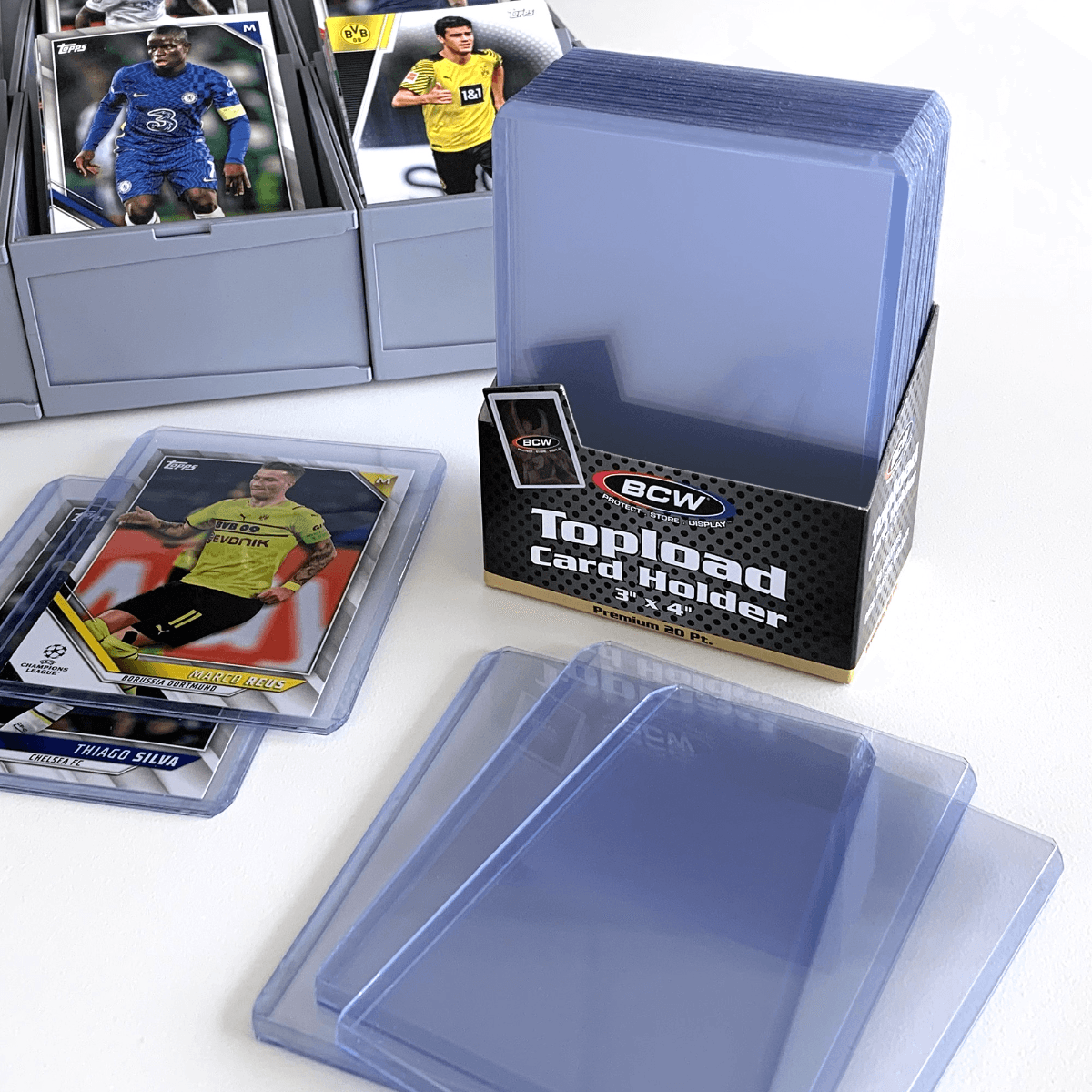 Pack of BCW 3x4 Topload Card Holders - Premium with a stack of premium toploaders and soccer cards in a modular sorting tray