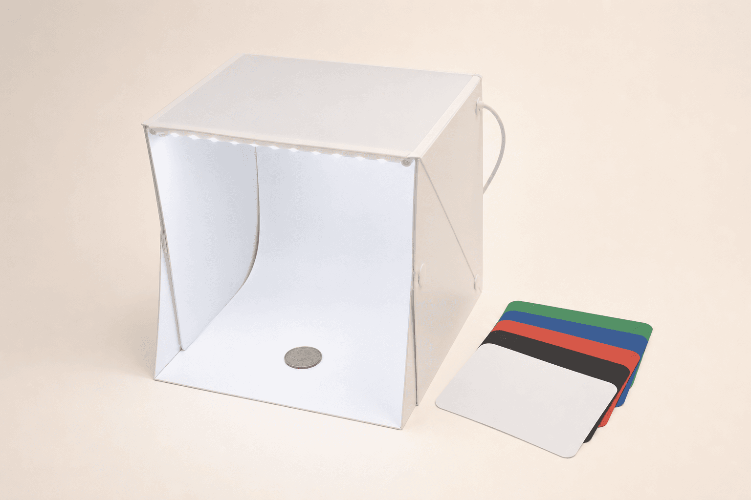 Original representative image of a compact folding LED photo light box and colored backdrop sheets for hobby coin photography.