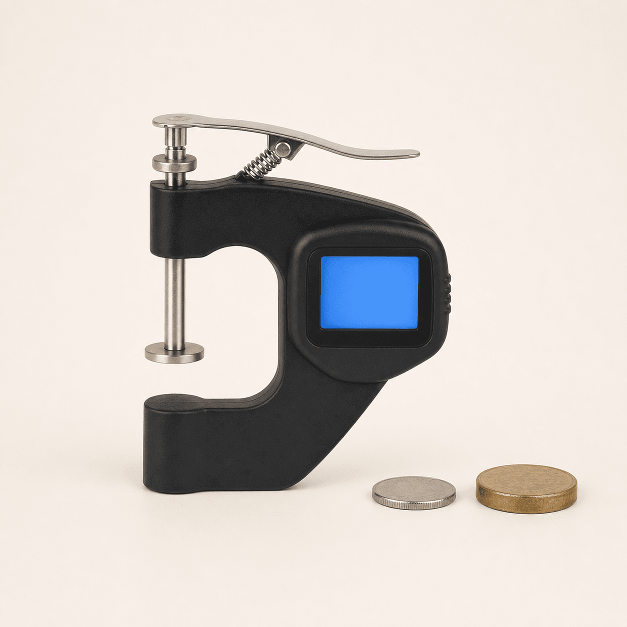 Original representative image of a black spring-loaded digital thickness gauge beside two generic coins.