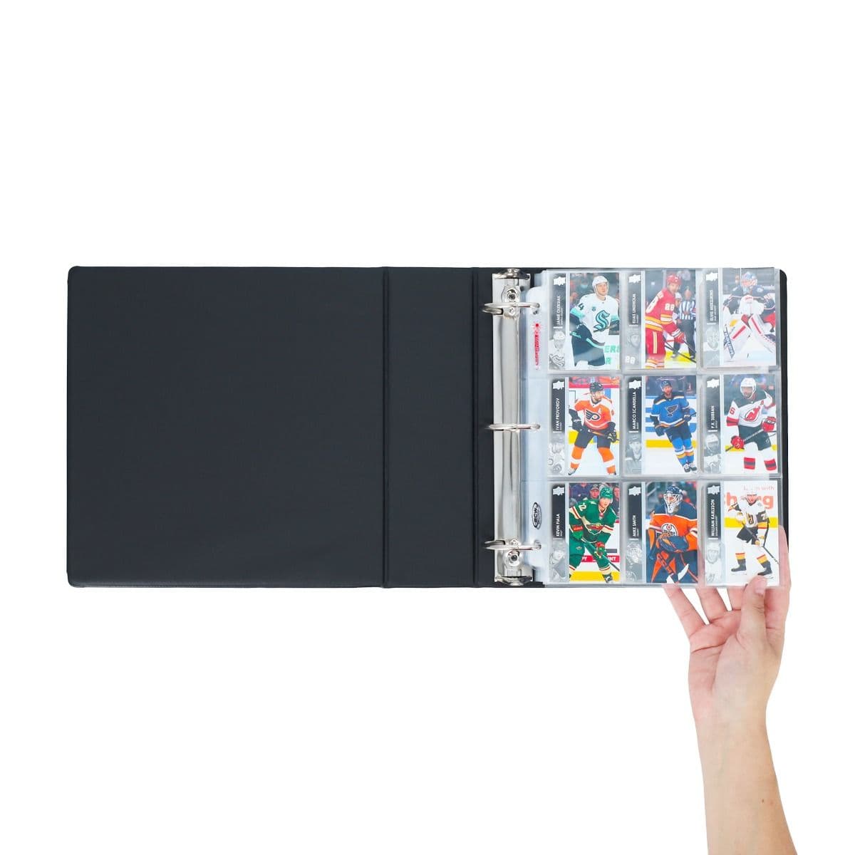BCW 3 in. Album - Hockey - Black, opened with pages full of hockey cards. hand flipping through the pages.