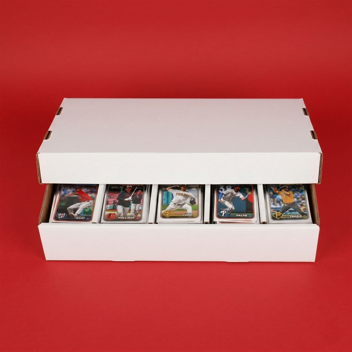 White BCW Sorting Tray Storage Box shown partially closed with the lid resting above the opening, revealing neatly organized stacks of trading cards inside the divided compartments against a red studio background.