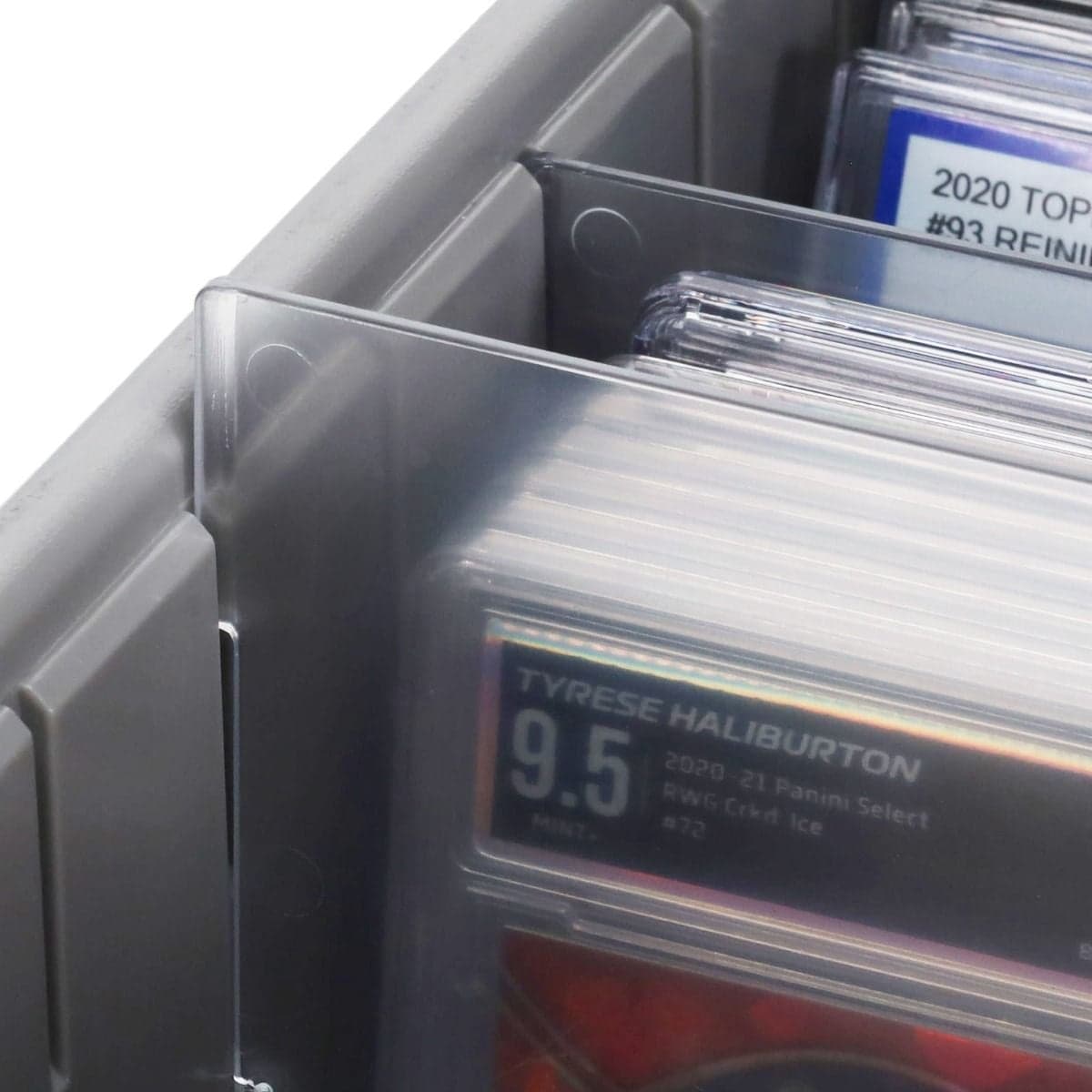Close-up view of a BCW graded card partition secured in a storage row, showing the translucent design that separates graded slabs while maintaining clear card visibility and organization.