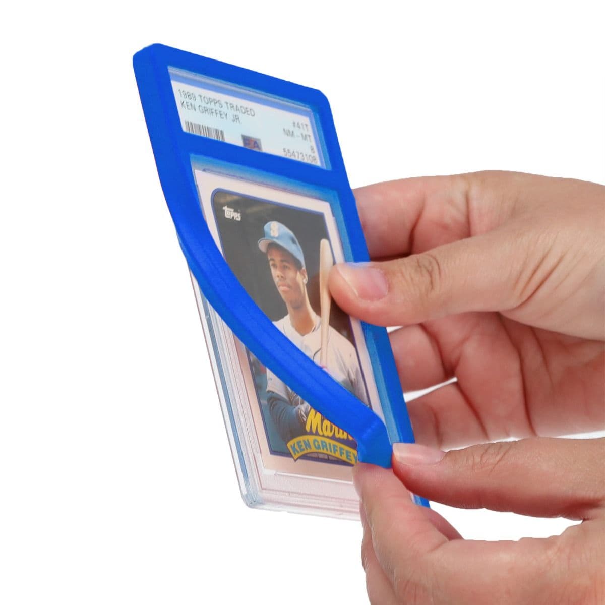 A person stretches a blue slab bumper over the edge of a graded trading card case, demonstrating flexible, impact-absorbing protection.