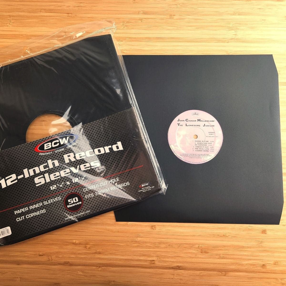 Package of BCW 12 Inch Record Paper Inner Sleeve - Cut Corners - Black on top of record in sleeve