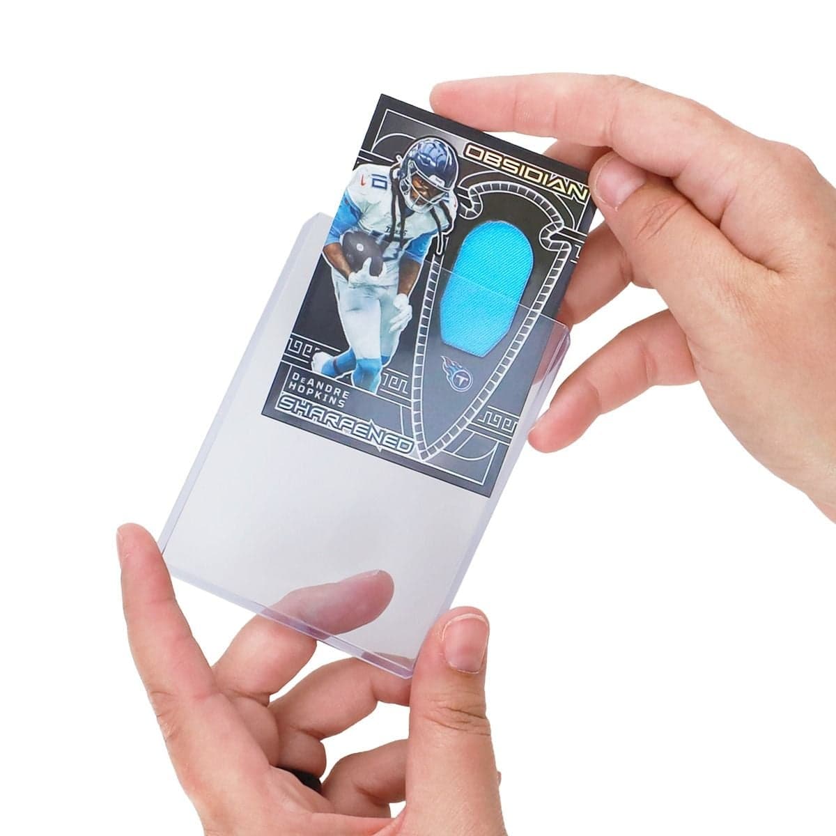 Hand inserting a thick sports trading card into a BCW 3" x 4" toploader designed for 138 pt. cards.