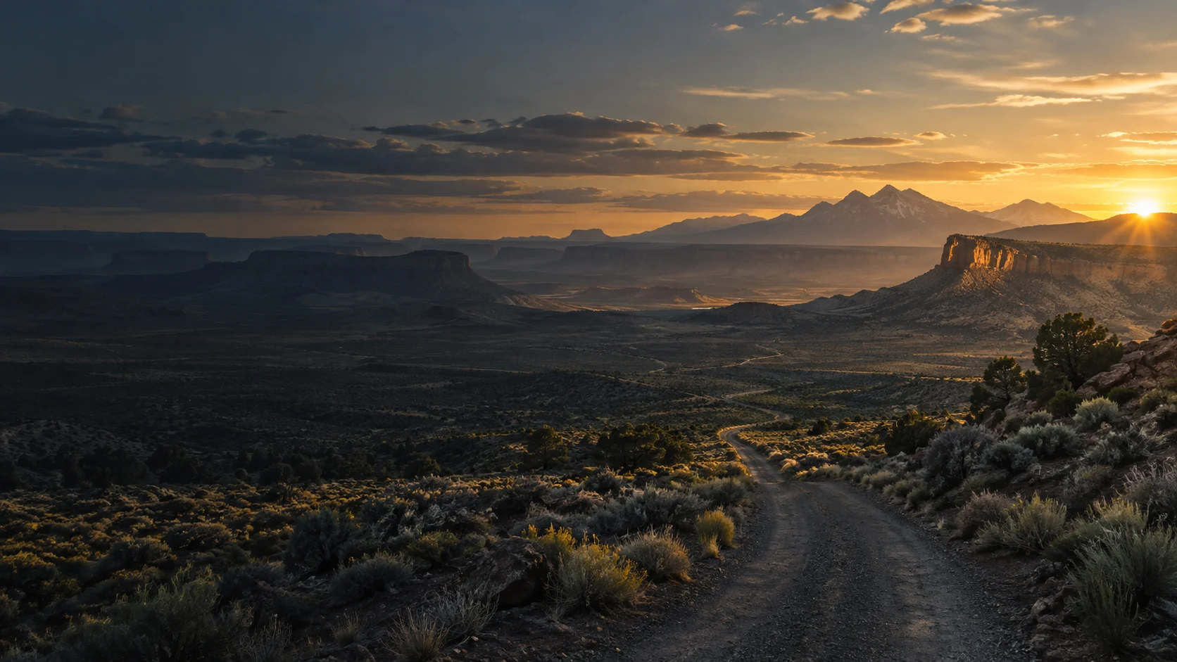 High desert road leading toward a sunlit mesa horizon